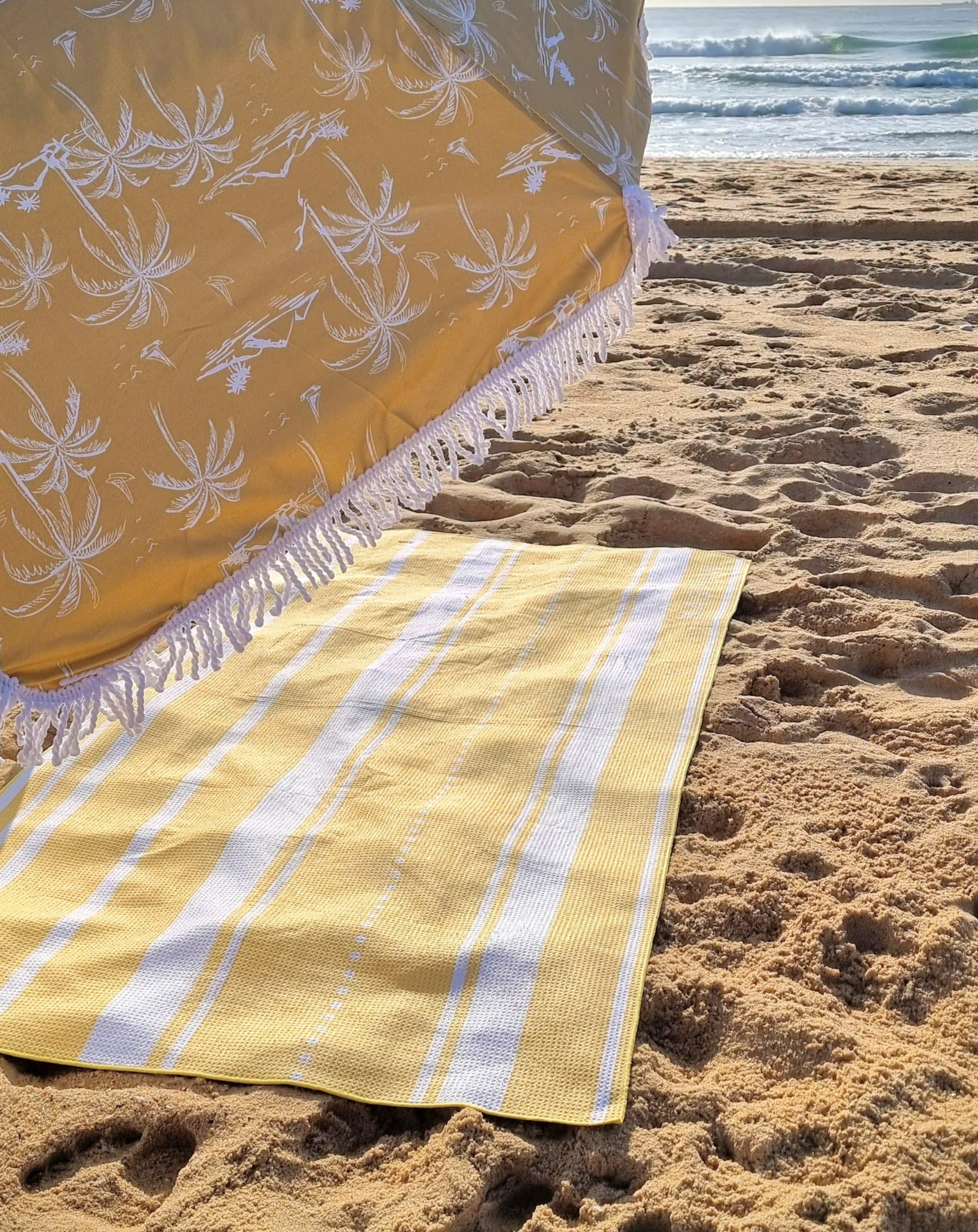 Yellow summer sand free towel at the beach