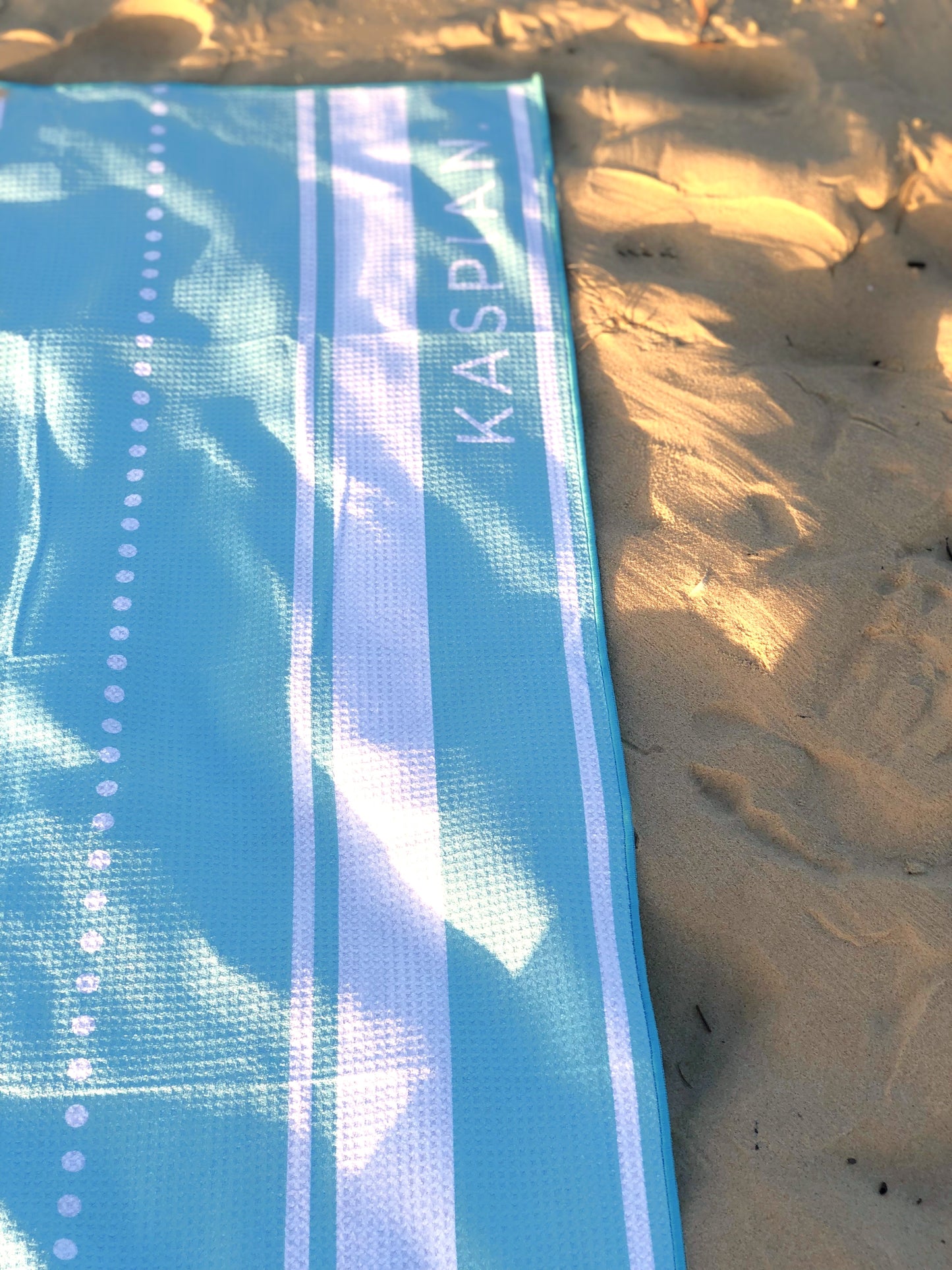 Aqua blue sand free towel at the beach